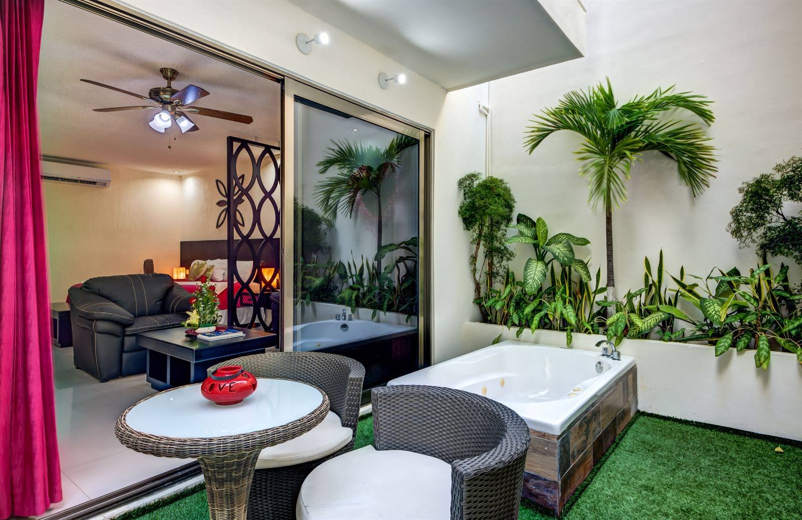 Suites Corazón: bathroom with a large tub and plants