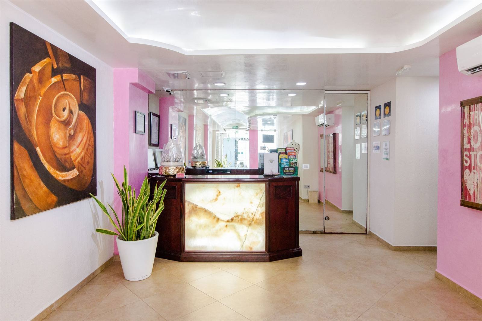 Suites Corazón: reception with a marble counter and artwork